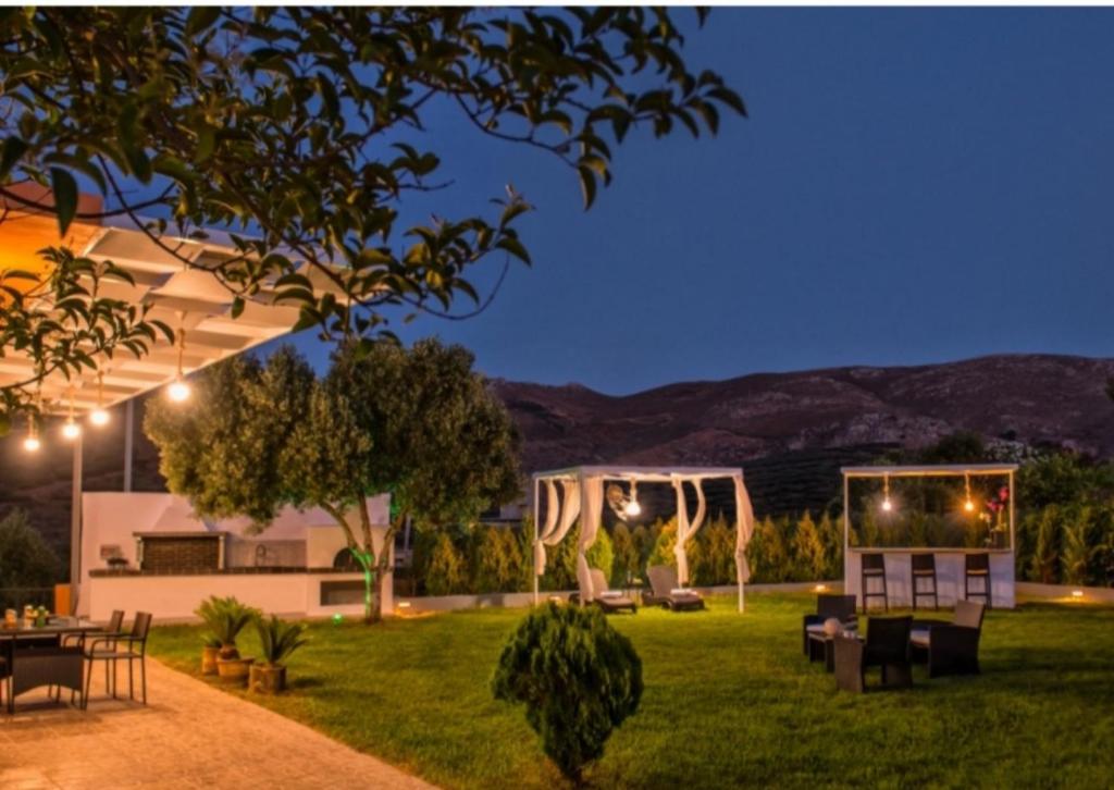 a yard with tables and chairs at night at 500 sqm Private Garden, Outdoor Kitchen, near Falasarna & Balos Beach in Falasarna