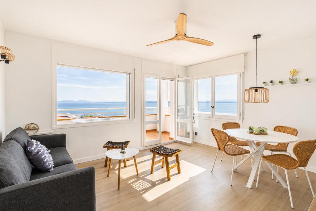 a living room with a couch and a table and chairs at Vista Roses Mar - Ariadna in Roses