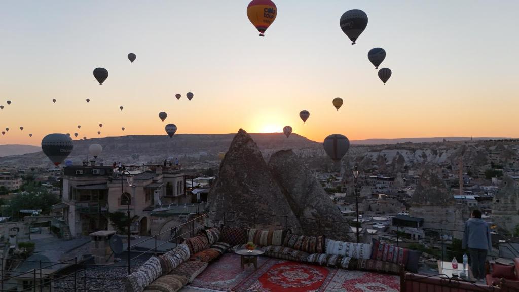 a group of hot air balloons flying over the pyramids at Harman Cave Hotel in Göreme