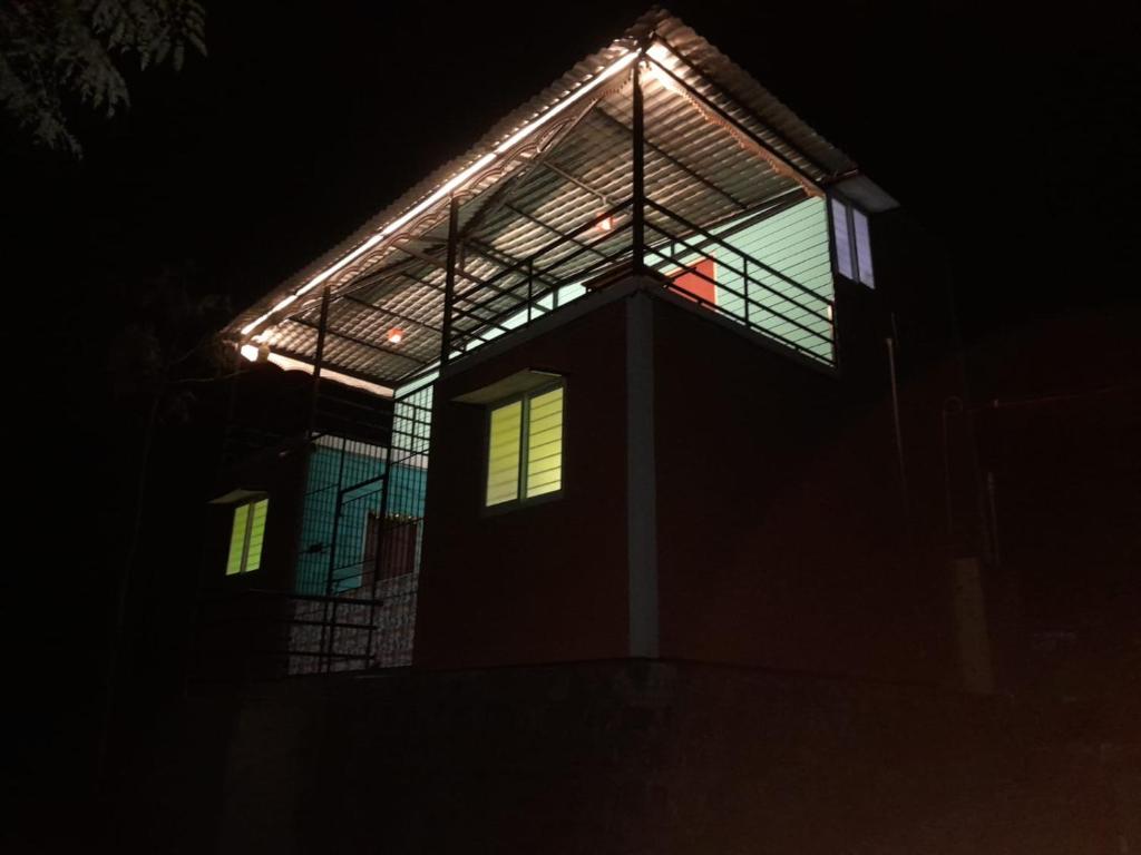 a building with lights on top of it at night at Pani thuzhi in Salem