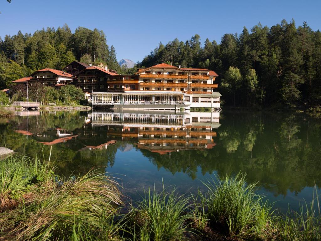 un riflesso di un hotel su un lago di Parkhotel Tristachersee a Lienz