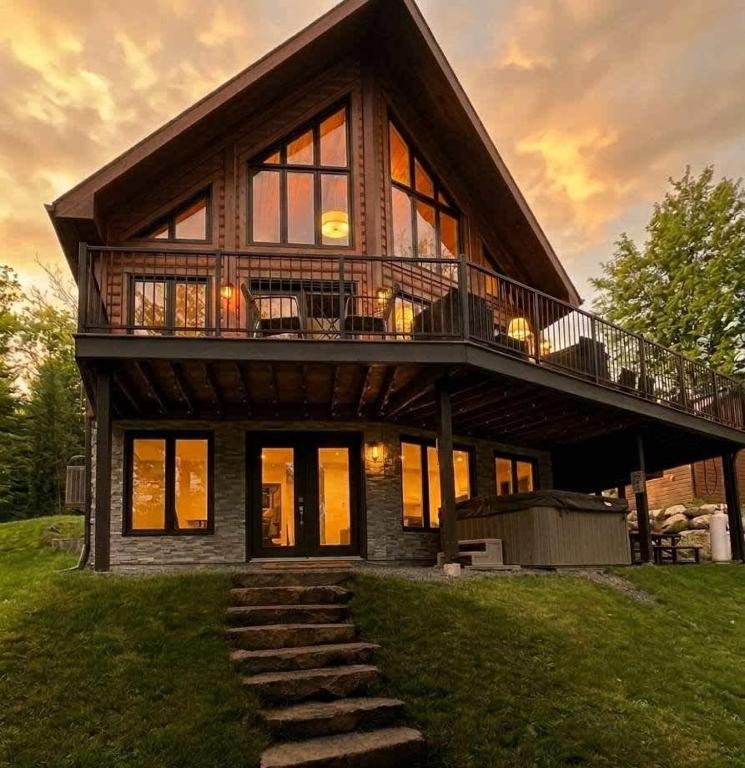 a large house with a deck on top of it at Lakefront - Spa - Pool table - Mistral 154 in Sainte-Marguerite