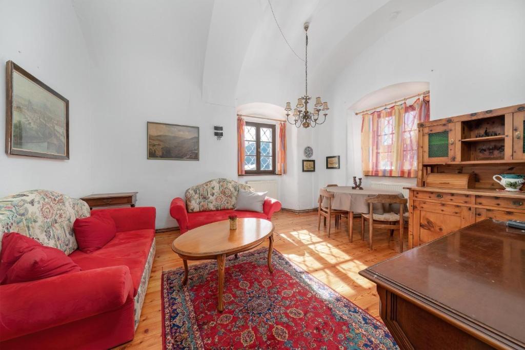 a living room with a red couch and a table at Schloss Berg Klösterle in Zedlitzdorf