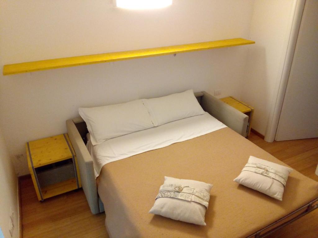mały pokój z łóżkiem z 2 poduszkami w obiekcie Luoghi Comuni Porta Palazzo w Turynie
