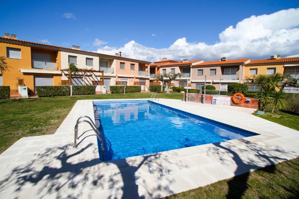a swimming pool in a yard with houses at Olivers Planet Costa Dorada in Cambrils