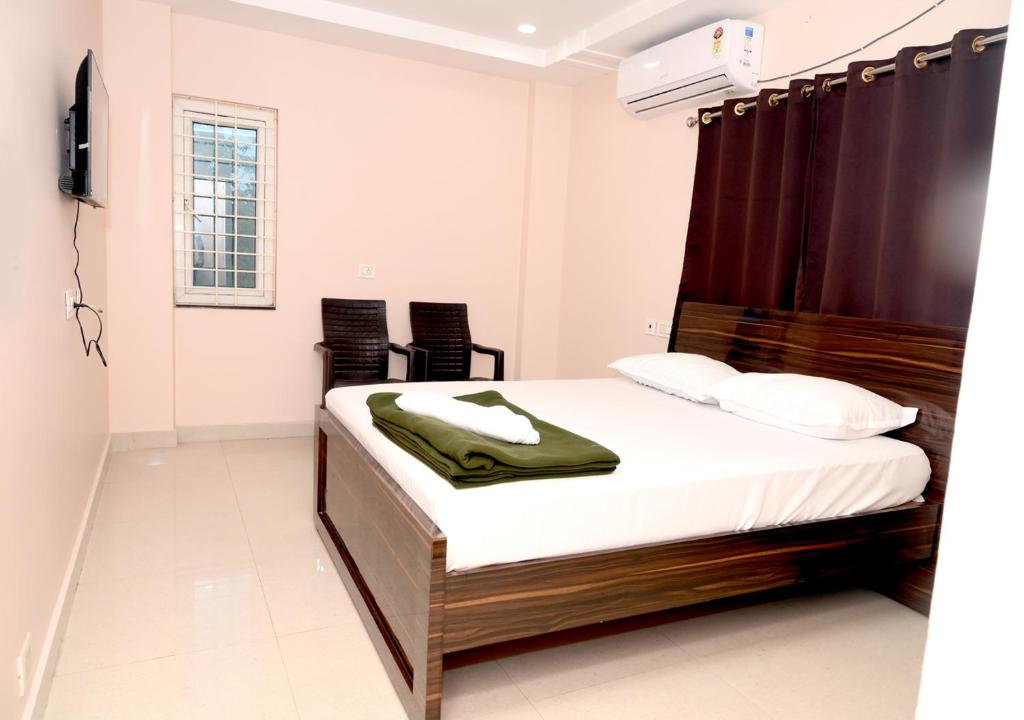 a bedroom with a bed and a television in it at Hotel Ram Way in Visakhapatnam