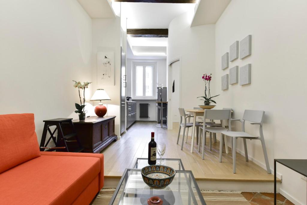 a living room with a red couch and a table at Campo de' Fiori Brand New Apartment in Rome