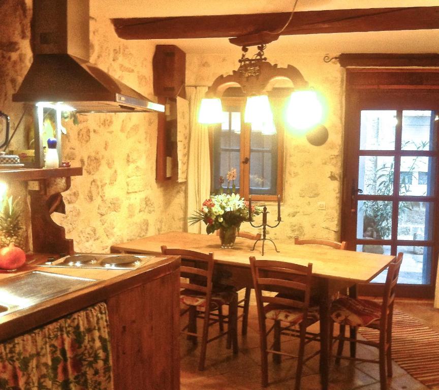 une cuisine avec une table en bois, des chaises et un îlot de cuisine dans l'établissement Apartment Maison La Roche, à Peyriac-de-Mer