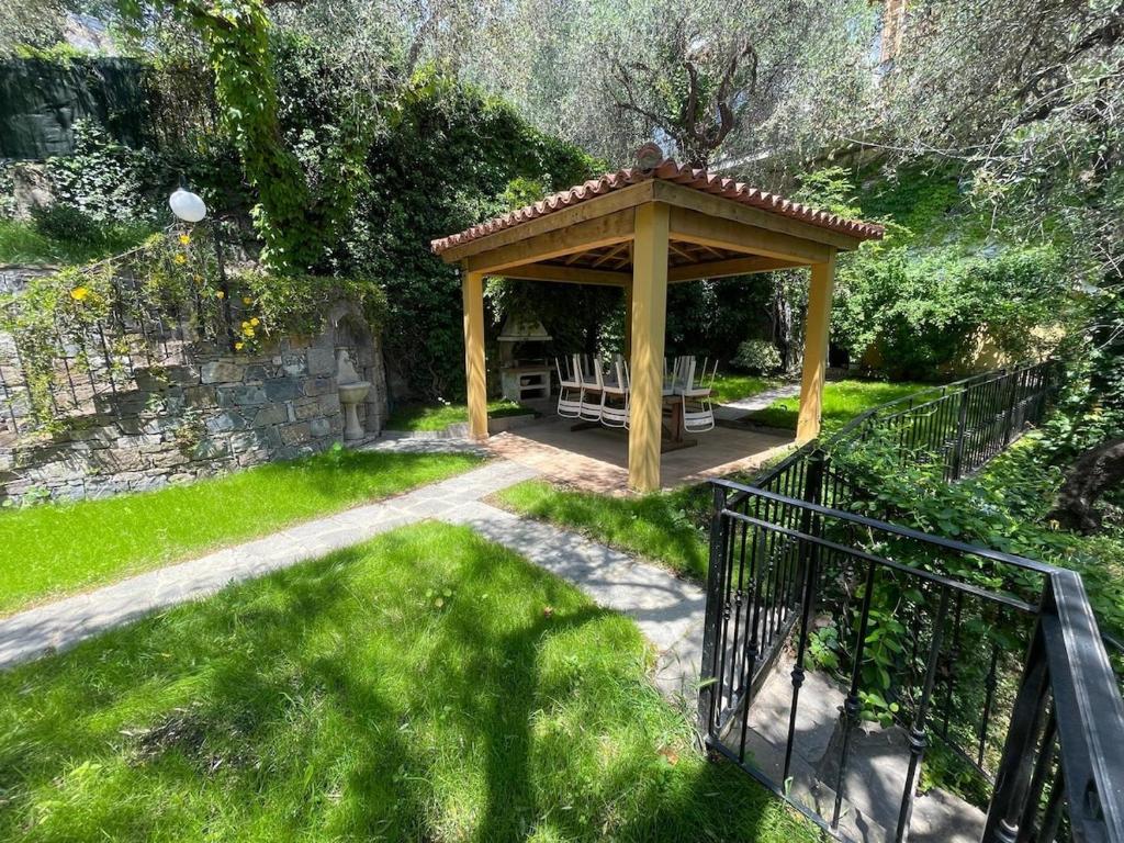 a gazebo with a bench in a yard at La villetta tra ulivi e colline in Civezza
