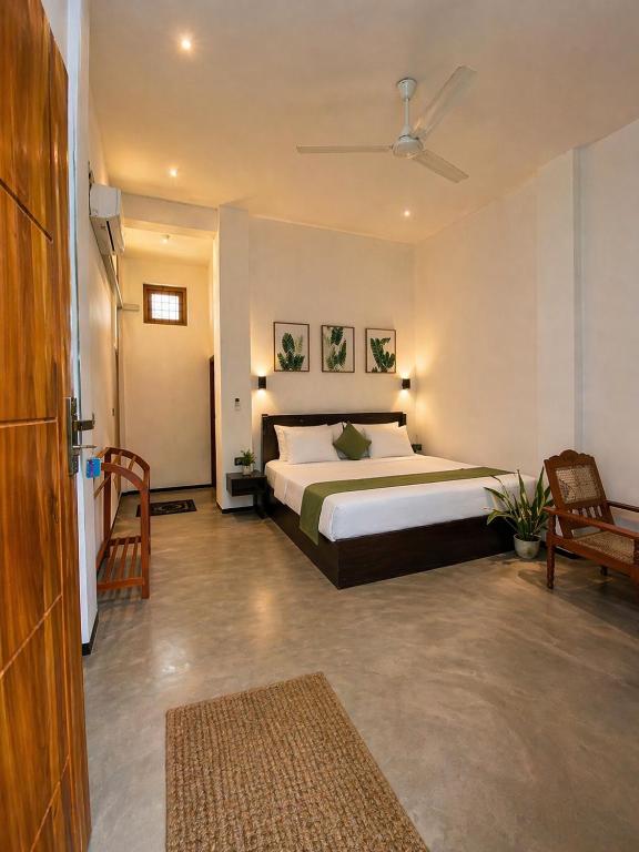 a bedroom with a large bed and a couch at FS Hotel & villa in Arugam Bay