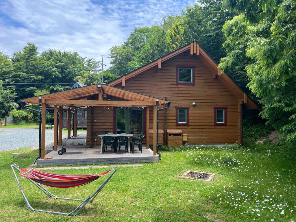 a log cabin with a table and chairs in the yard at Family Cottage Pokhara in Yamanakako