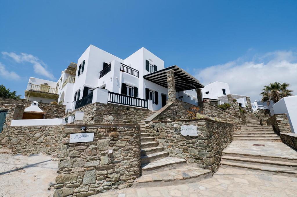 a building with a stone wall and stairs at To Pelagos in Agios Sostis