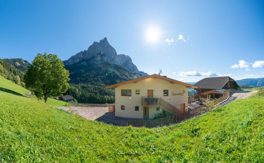 a house on a hill with mountains in the background at Schmalzlhof in Siusi