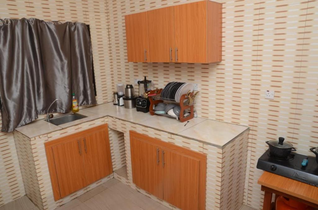 a kitchen with a counter top with a sink and aounter at Besta Apartments in Akure
