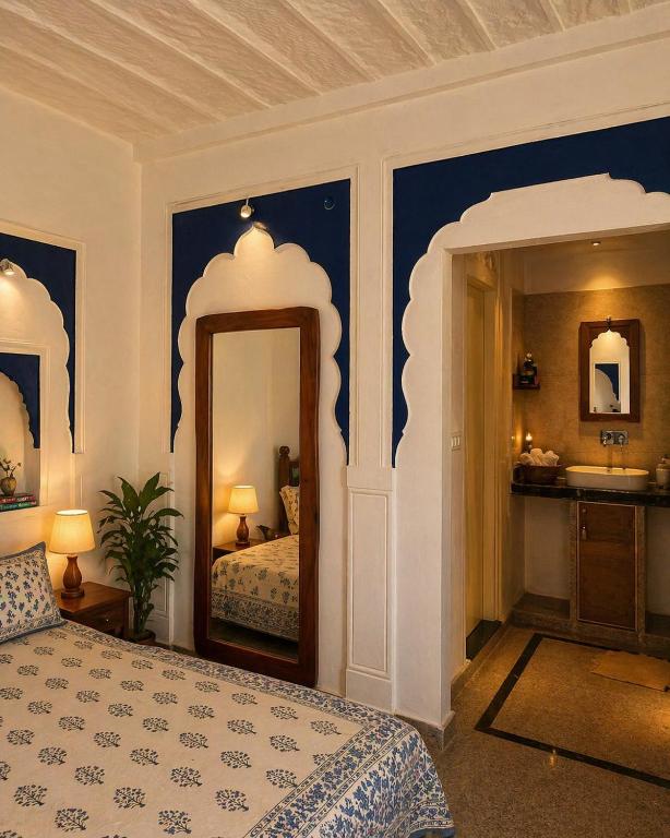 a bedroom with a bed and a mirror and a sink at Garh Harsolav in Harsolāv