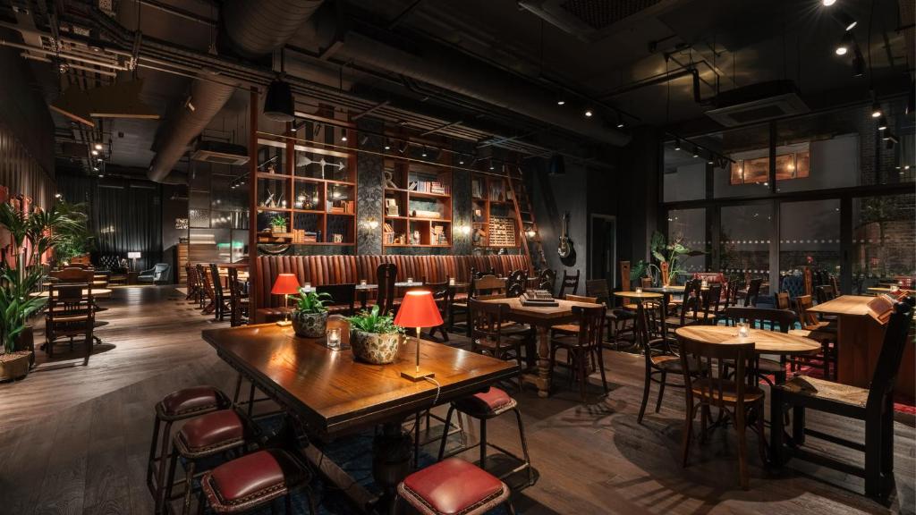 a restaurant with tables and chairs in a room at Ruby Stella Hotel London by IHG in London