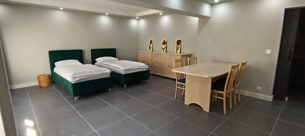 a room with two beds and a table with chairs at Central Studio Abrud in Aktenburg