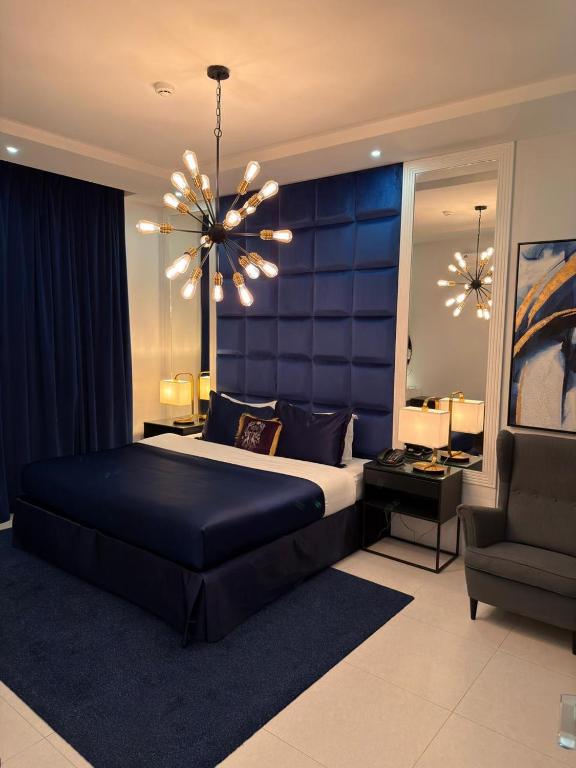 a bedroom with a large bed and a chandelier at دانة الرياض للشقق المخدومة2 - Dana Serviced Apartments2 in Riyadh