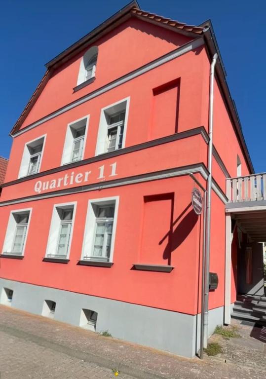 a red building with the number on it at Pension Quartier 11 in Waren