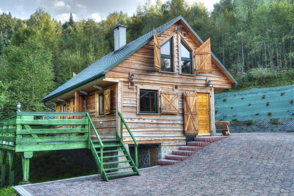 ein kleines Holzhaus mit einer Treppe davor in der Unterkunft Świerkowe Zacisze Domki in Budzów