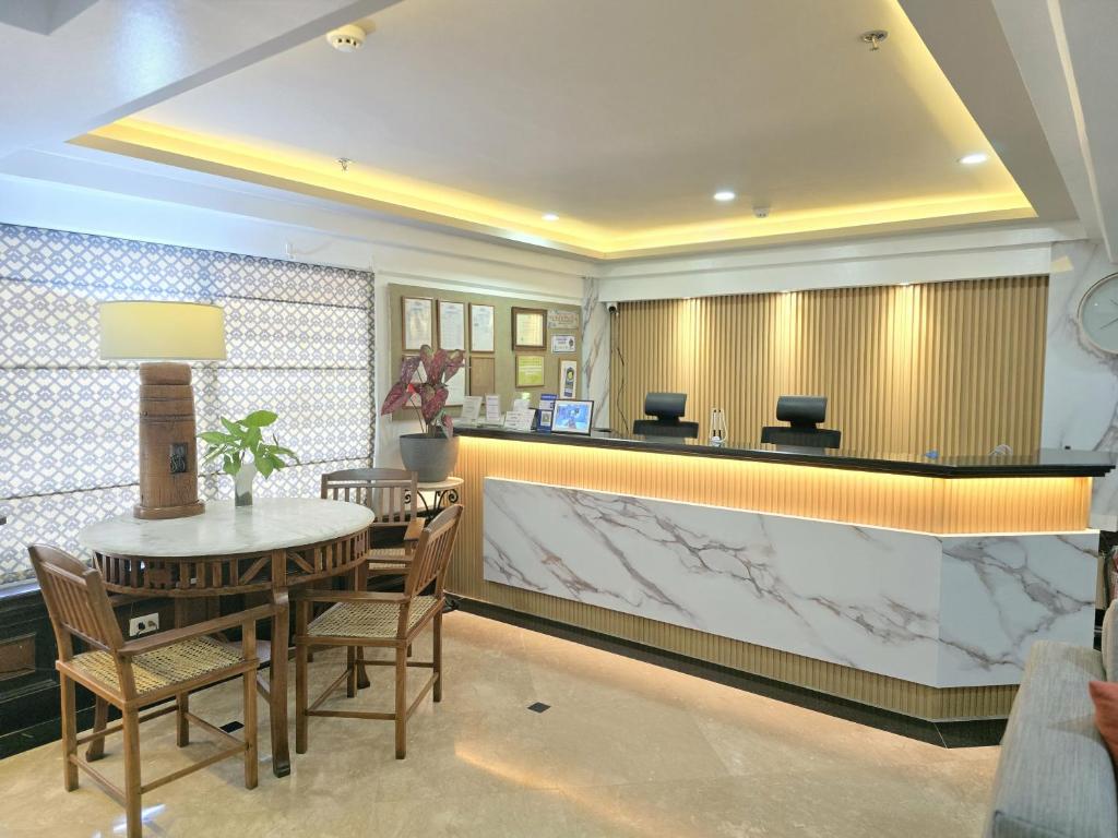 a dining room with a counter and a table and chairs at Ralph Anthony Suites Hotel in Manila