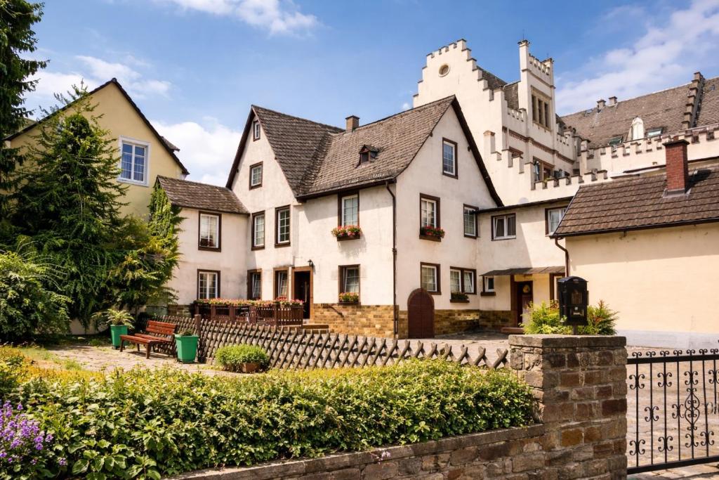 a large white house with a fence at Fewo Am Brunnen in Rüdesheim am Rhein