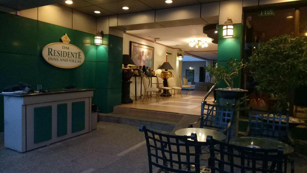 un restaurant avec un mur vert et un panneau. dans l'établissement DM Residente Hotel Inns & Villas, à Ángeles