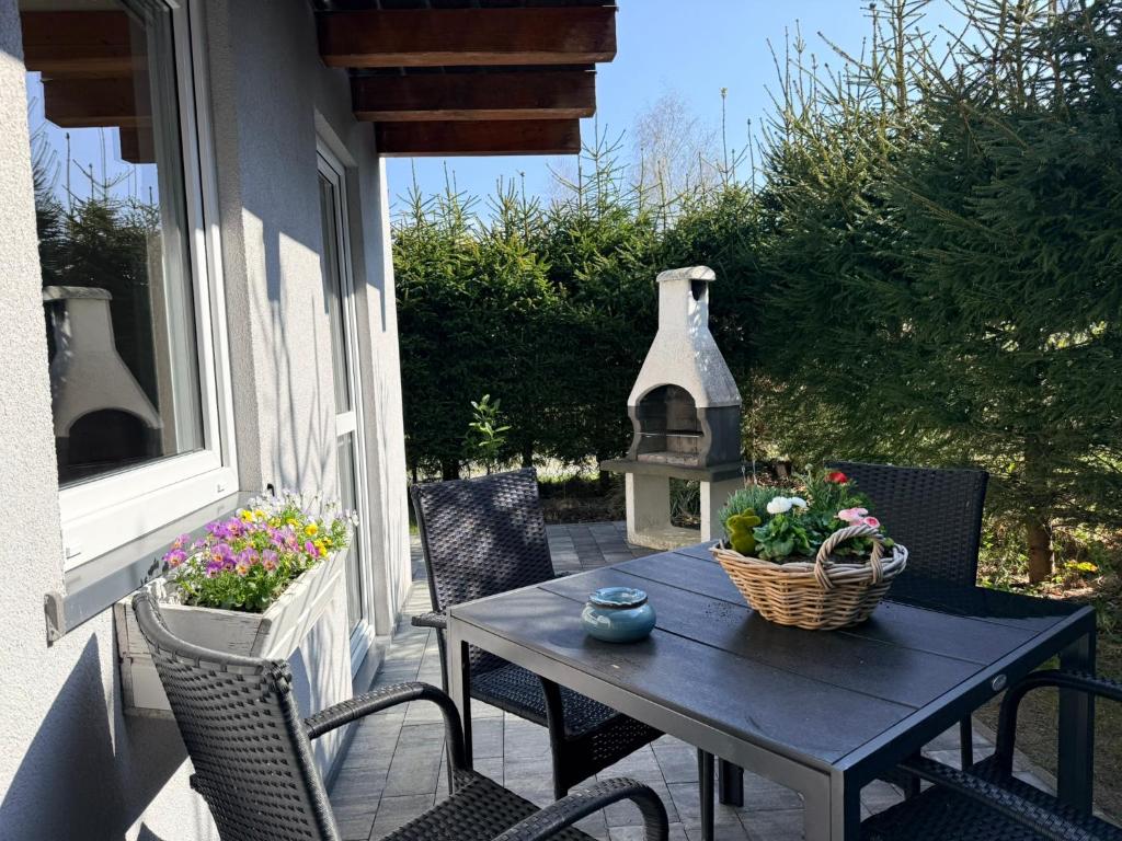 a table and chairs on a porch with flowers at Domki Letniskowe Stokrotka in Pustkowo