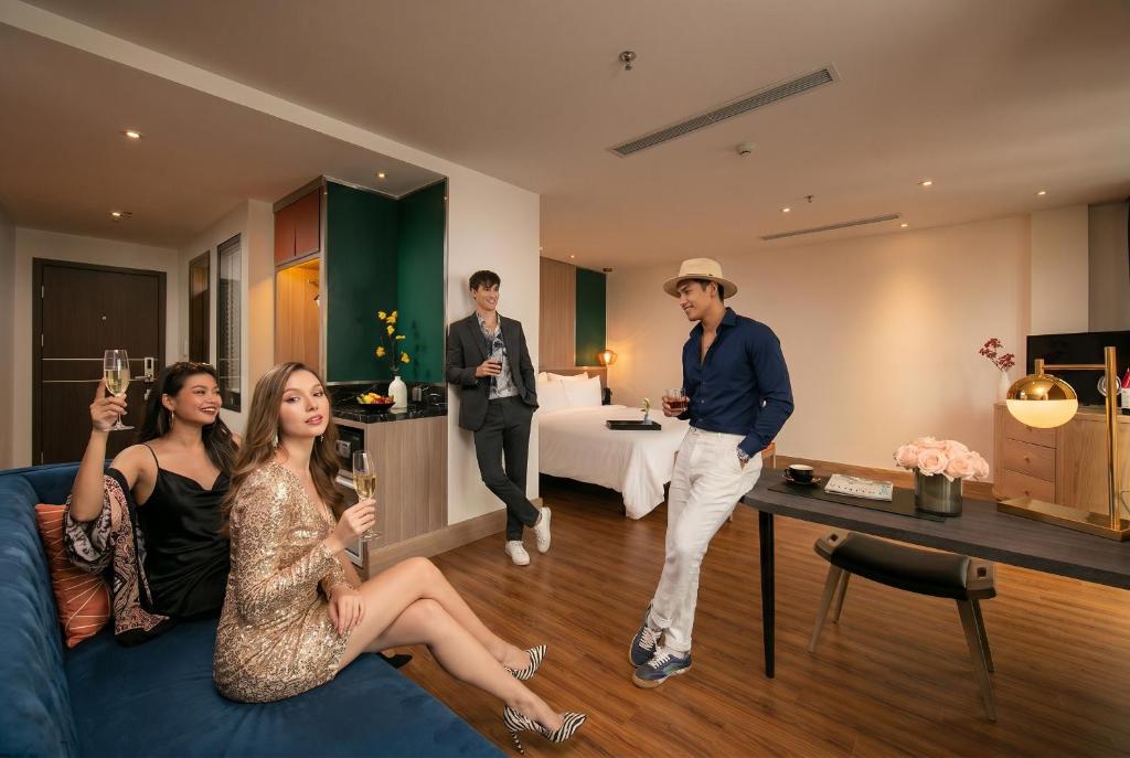 a group of people standing in a living room at Aurora Premium - A Lifestyle Hotel in Hanoi