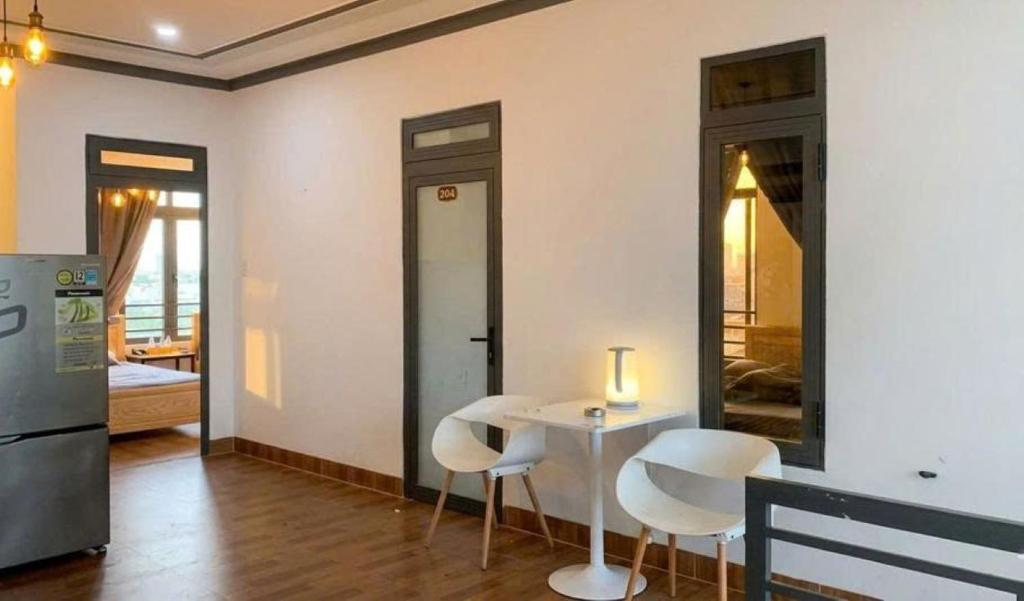 a room with a table and chairs and a kitchen at Nomad homestay in Ninh Hải