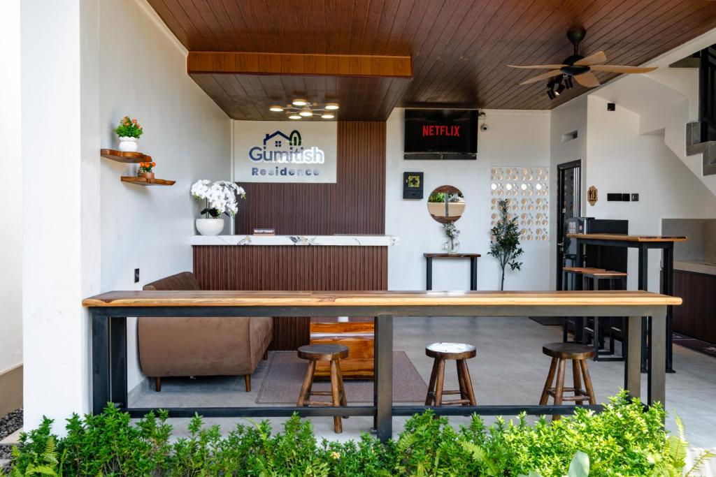 a bar in a restaurant with stools at Gumitish Residence Singaraja in Singaraja