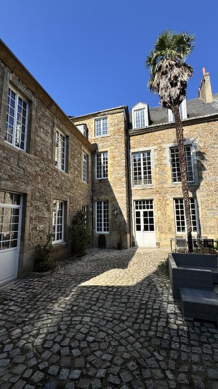 a large brick building with a palm tree in front of it at Maison Saint Christophe in Le Mans