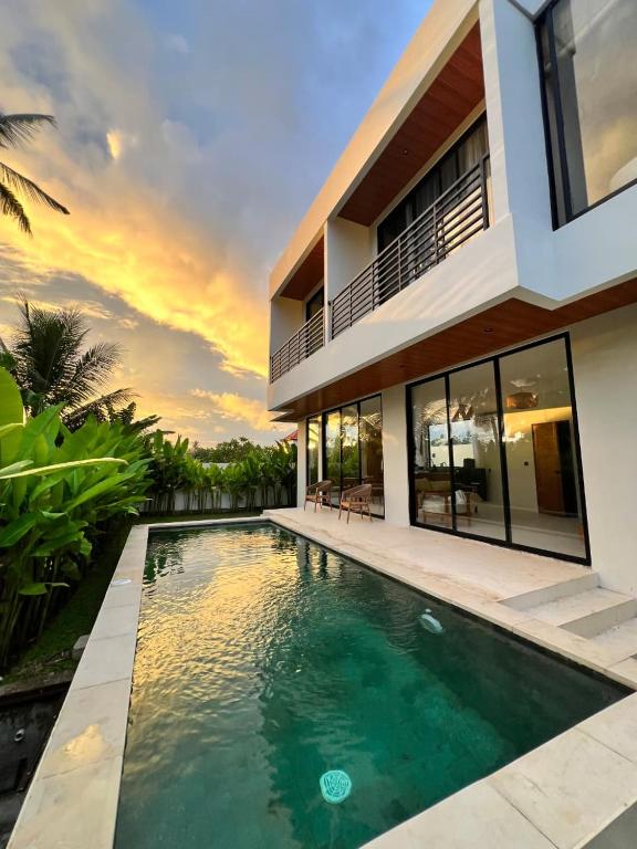a villa with a swimming pool in front of a house at Santara Villa Ubud in Ubud
