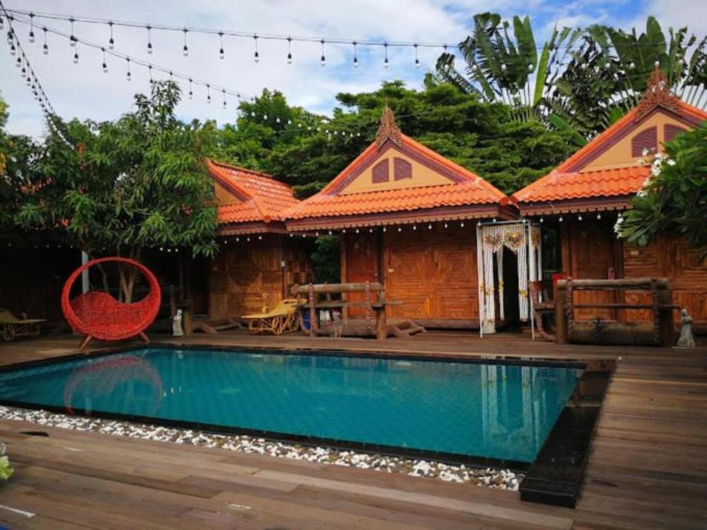 a house with a swimming pool in front of a house at Montri Resort Donmuang Bangkok in Ban Don Muang (1)