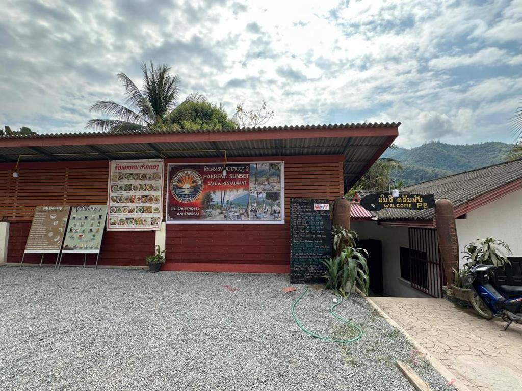 a restaurant with a motorcycle parked outside of a building at PAKBENG SUNSET DORM Room in Pakbeng