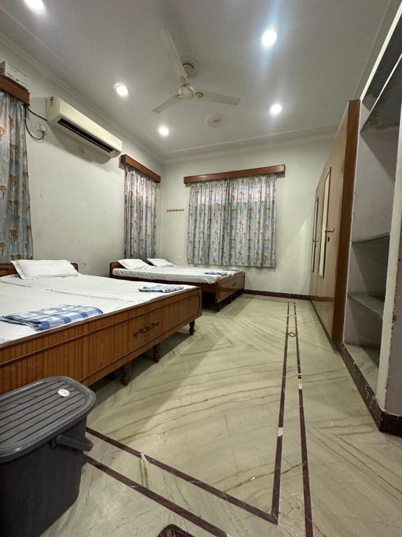 a room with three beds and a staircase in it at Ashish Marriage Place in Jaipur