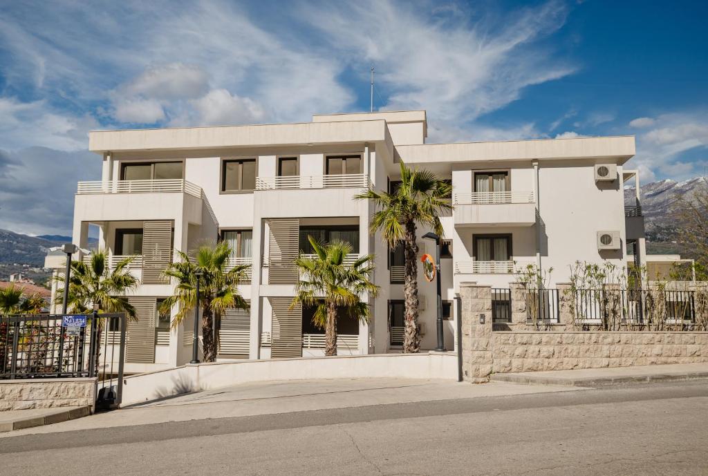 a white building with palm trees in front of it at Adriatic Sea Escape B20 in Herceg-Novi