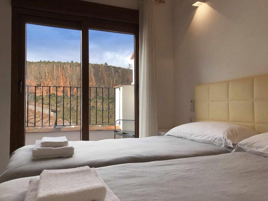 a bedroom with a bed and a large window at Alojamiento con terraza en Chulilla in Chulilla