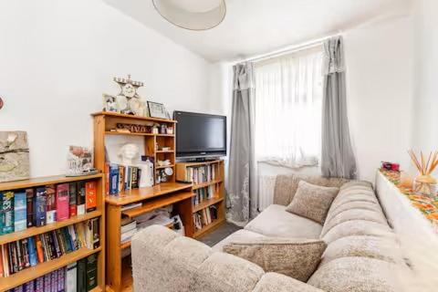 a living room with a couch and a tv at Rest & Nest in Chelsfield