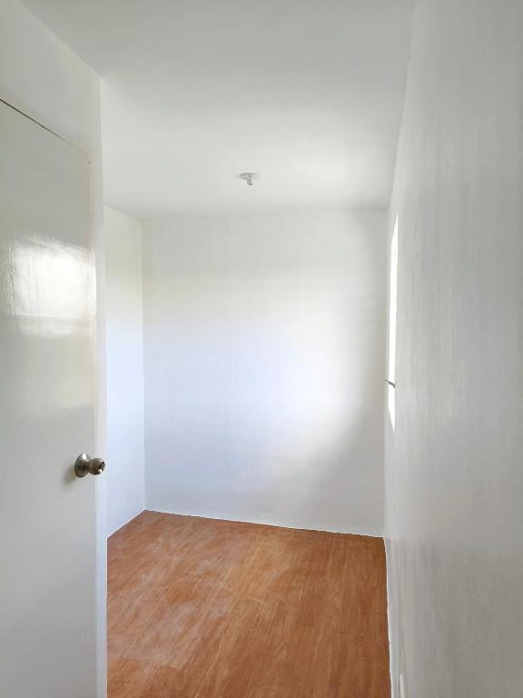 an empty room with white walls and a wooden floor at camella palawan in Puerto Princesa City