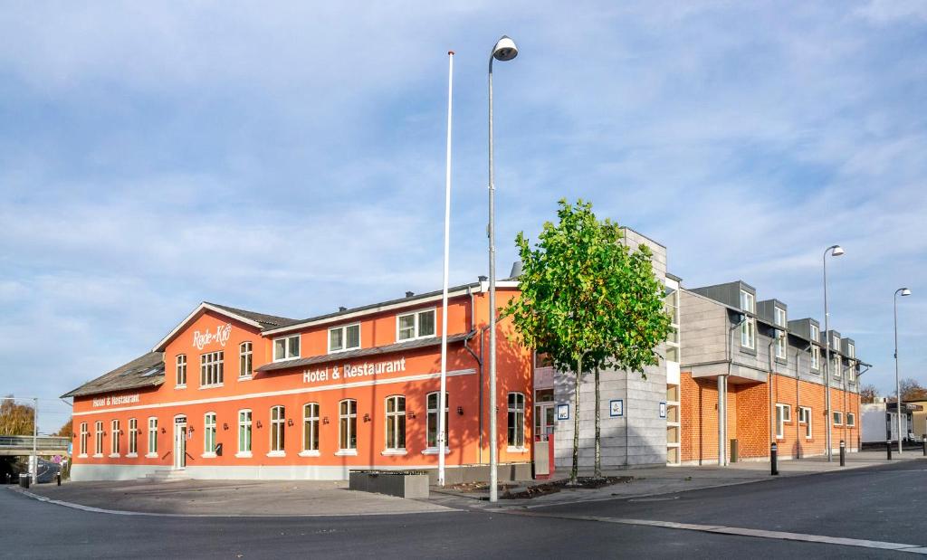 an orange building with a tree in front of it at Hotel Røde-Kro in Rødekro