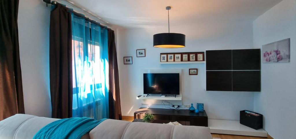 a living room with a couch and a television at Apartamento El Toboso in Alcalá de Henares