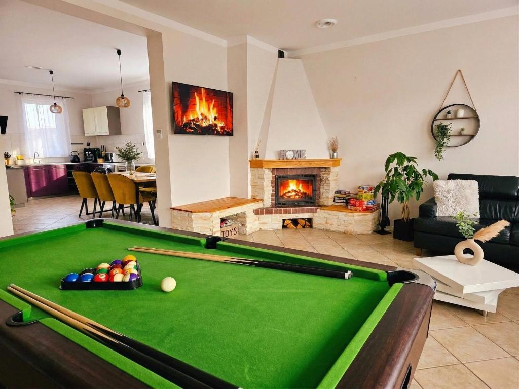 a living room with a pool table and a fireplace at Dom Pod Świerkiem in Ostróda