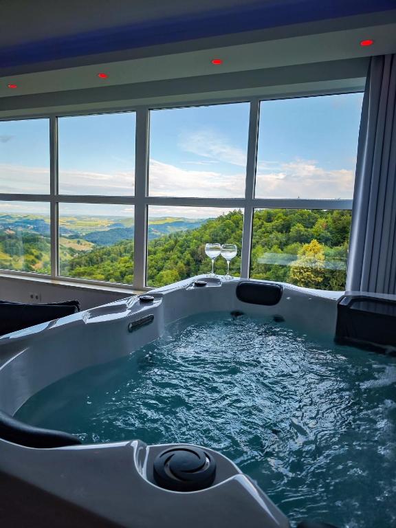 a jacuzzi tub in a room with windows at Private wellness with panoramic view, sauna & jacuzzi in Maribor