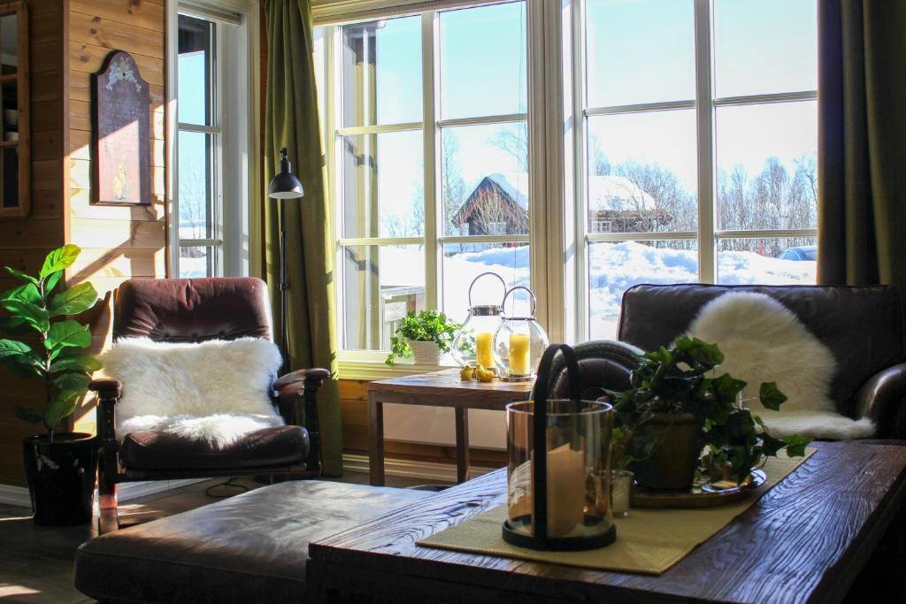 a living room with a table and a large window at Grønebakkins smørøye in Beitostøl