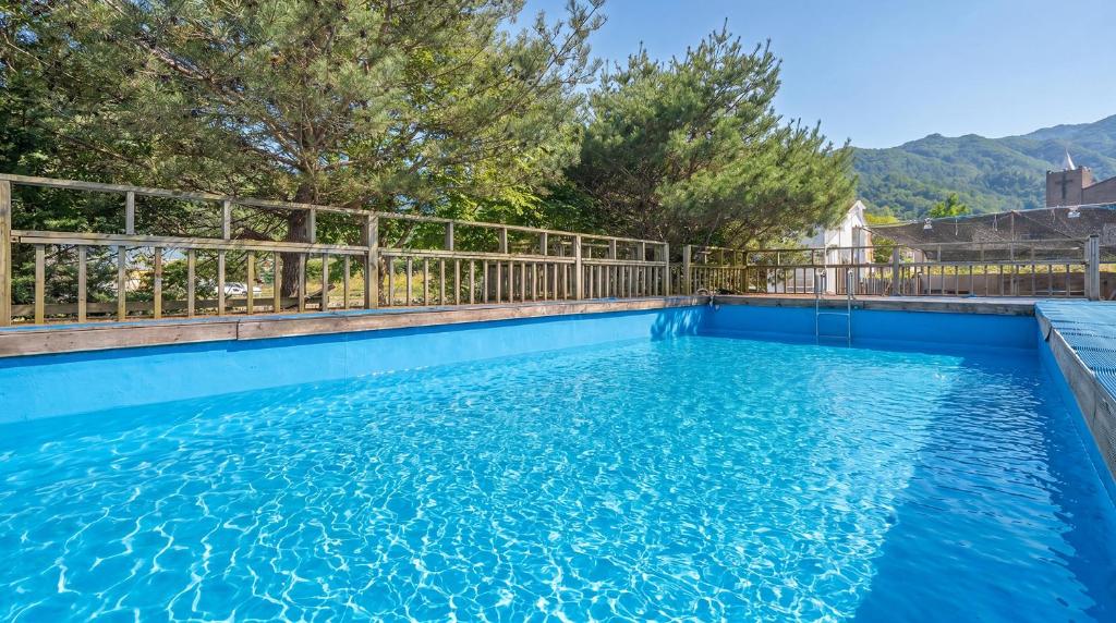 a swimming pool with a fence and blue water at Gapyeong Haneuldari pet pension in Gapyeong