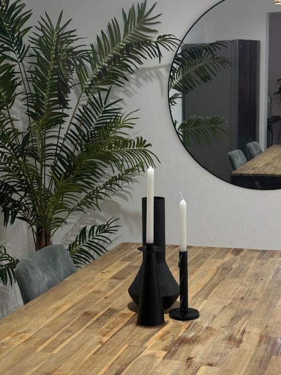two candles on a wooden table in a dining room at Coastal Sands Azores in Ribeira Grande