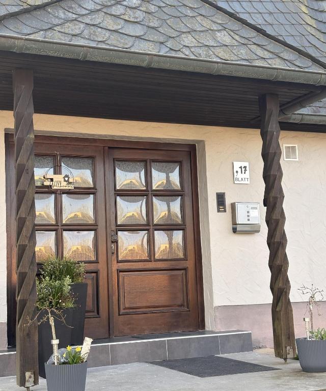 a wooden door of a house with two potted plants at Ferienwohnung "Zum Pfadfinder" in Thalfang