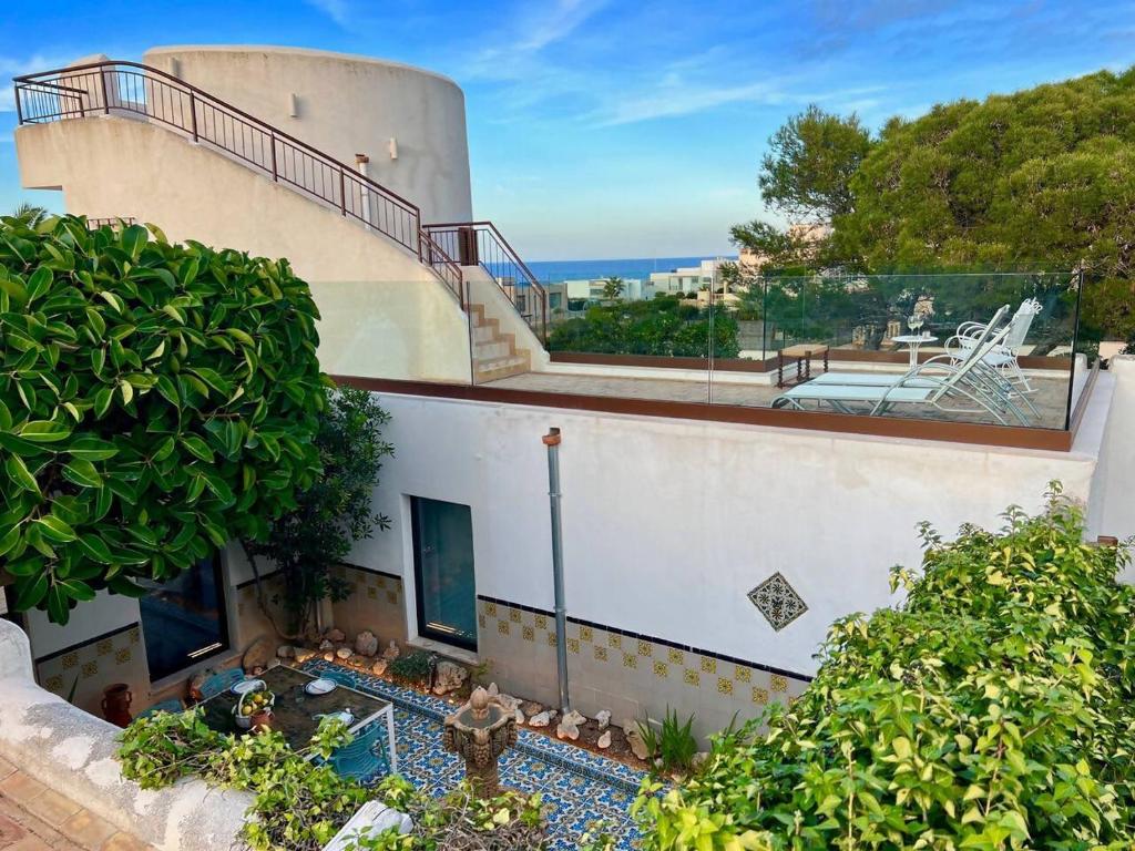 a house with a balcony and a swimming pool at Villa Sa Torre Blanca in Colonia de Sant Pere