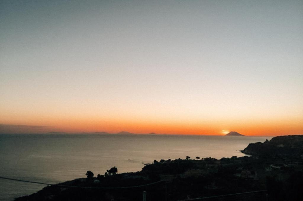a sunset over the ocean with the sun in the sky at Villa Donna Cà con vista mare e piscina privata in Coccorino